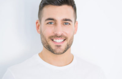 A man smiles on a white background.